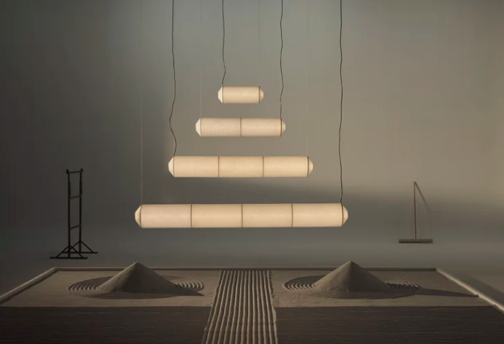 Tekio hanging lamp by Anthony Dickens in Japanese washi paper with black cord suspended in a living room setting with warm ambient light.