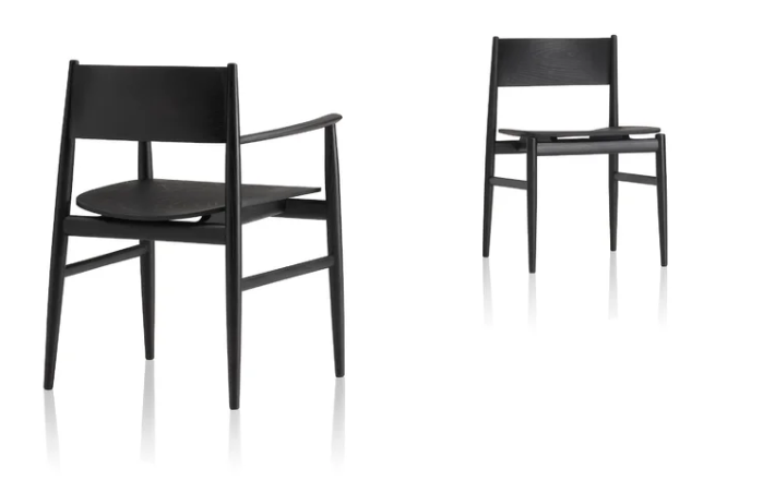 Two Neve dining chairs in black wood, one with armrests and one armless side chair, featuring minimalist Scandinavian design with tapered legs, clean lines, and a sculptural solid wood seat on a white background.