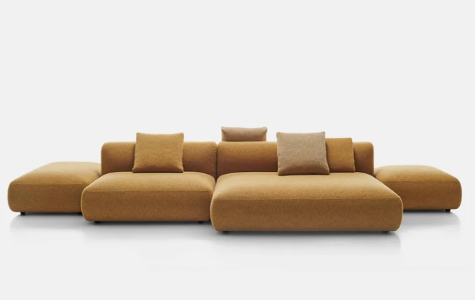 Cosy Island modular sectional sofa in mustard yellow upholstery featuring a low-profile design with chaise lounges on both ends and coordinating throw pillows, displayed on a white background