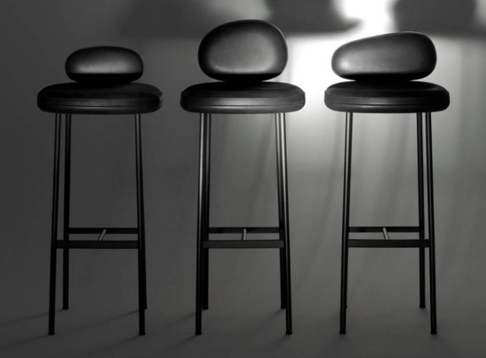 Pebble stools featuring rounded, organic pebble-shaped backrests and cushioned leather seats on slim, four-legged black metal frames.