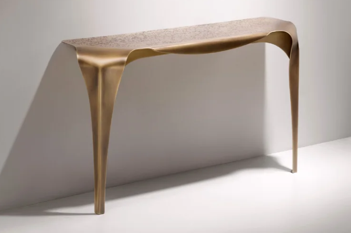 Convivium sculptural solid brass console positioned against a foyer wall.
