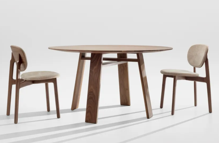 Zenso dining chair by Formstelle in solid walnut with leather seat in a modern dining room alongside a wood table.