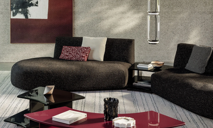 Dao Soft sectional sofa featuring dark charcoal textured fabric upholstery, curved low-profile seating, and accent pillows, styled with a low side table and glossy coffee tables.