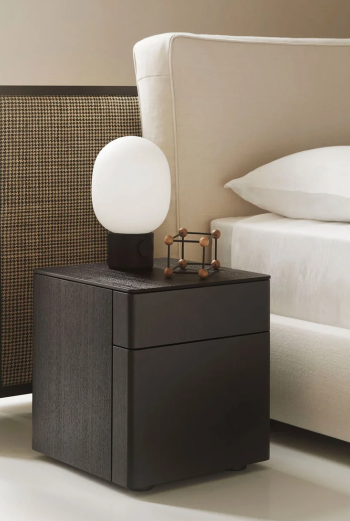 Comodino Byron nightstand by Piero Lissoni with rounded ash frame and Black Sugi melamine interior beside a designer bed.