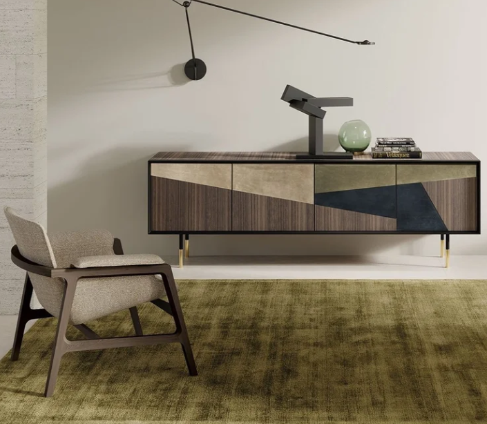 Norman cabinet by Euro Sironi in nabuk leather finish with black metal handles and glass shelving in a refined living room setting.