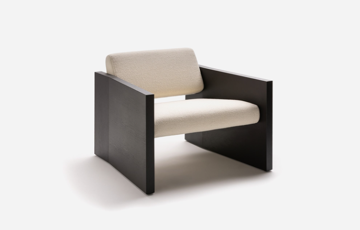 Modern Haven armchair by Yabu Pushelberg featuring off-white textured upholstery framed by a dark wood architectural block base.