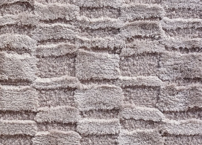 Luxury Fendley rug featuring a close-up view of a high-pile light gray plush weave with a textured geometric grid pattern.