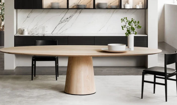 Materic dining table featuring an oval light natural wood tabletop resting on a central truncated cone base, styled with minimalist black wooden chairs.