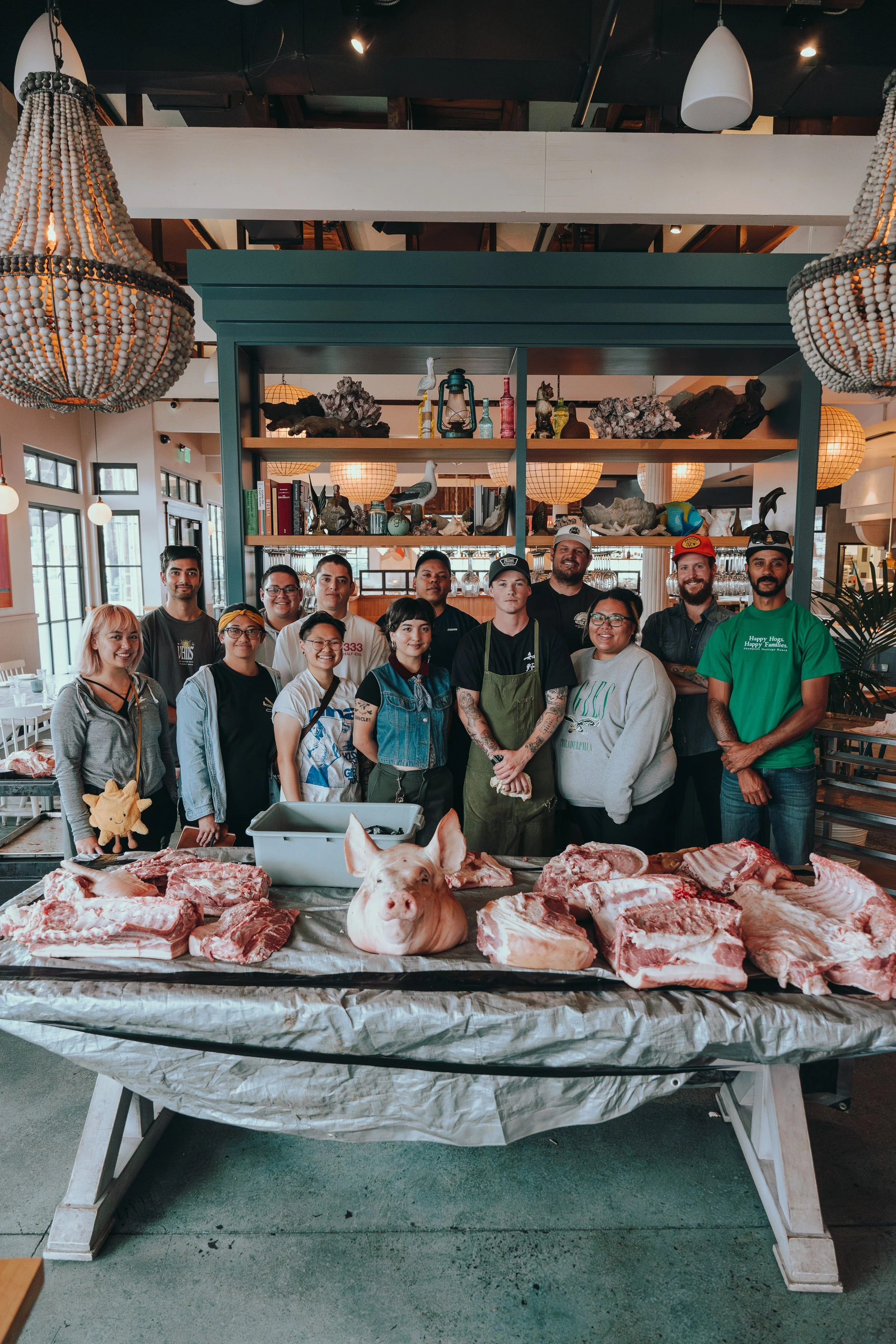 Aidan Owens teaching his culinary team how to butcher a pig at Herb & Wood and Herb & Sea in San Diego, demonstrating expert technique and leadership.