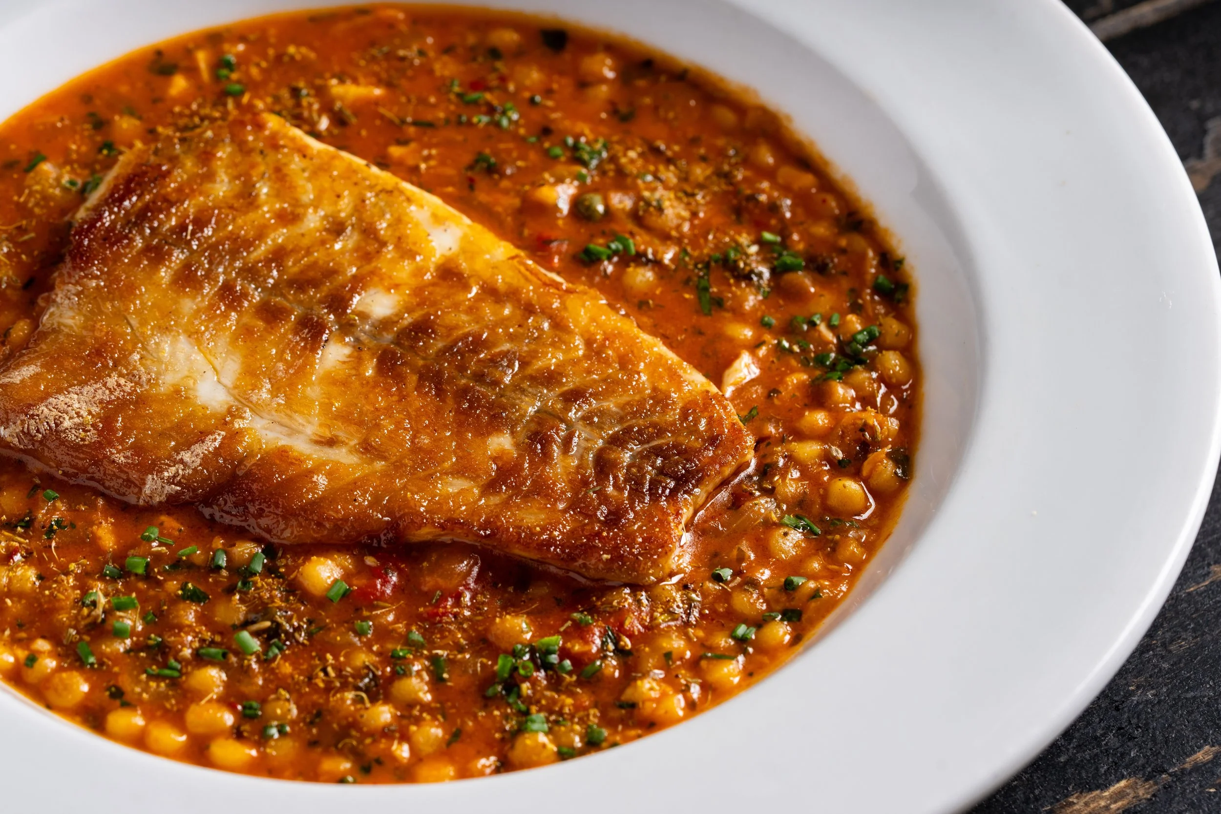Chef Aidan Owens demonstrating expert fish grilling tips in The Daily Meal