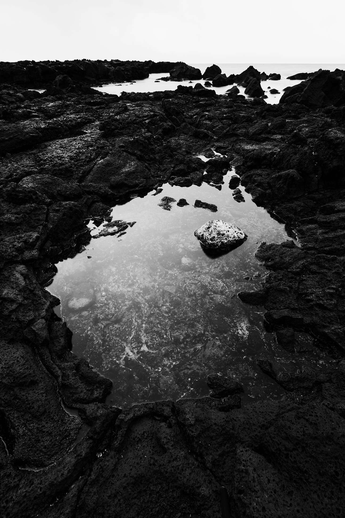 tide pool with salt covered stone in it on Jeju