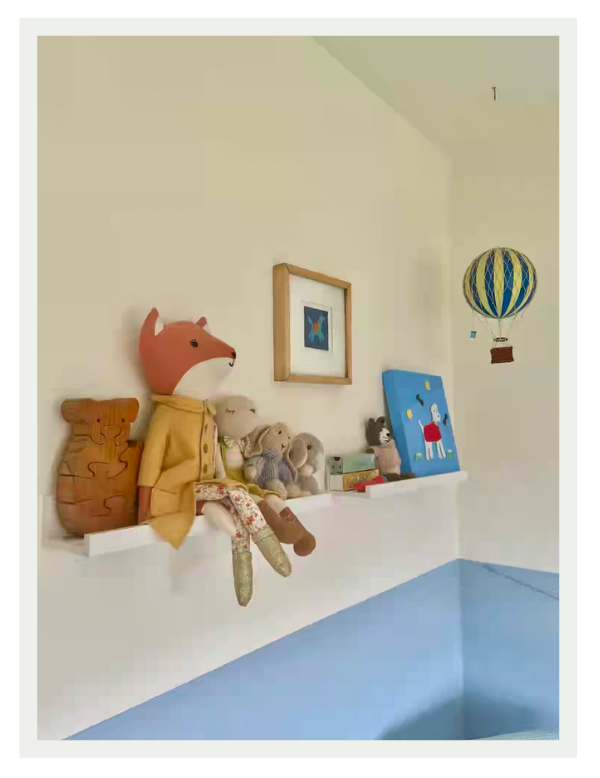 Colourful cushions, artwork and accessories adding personality to a timeless child's bedroom.