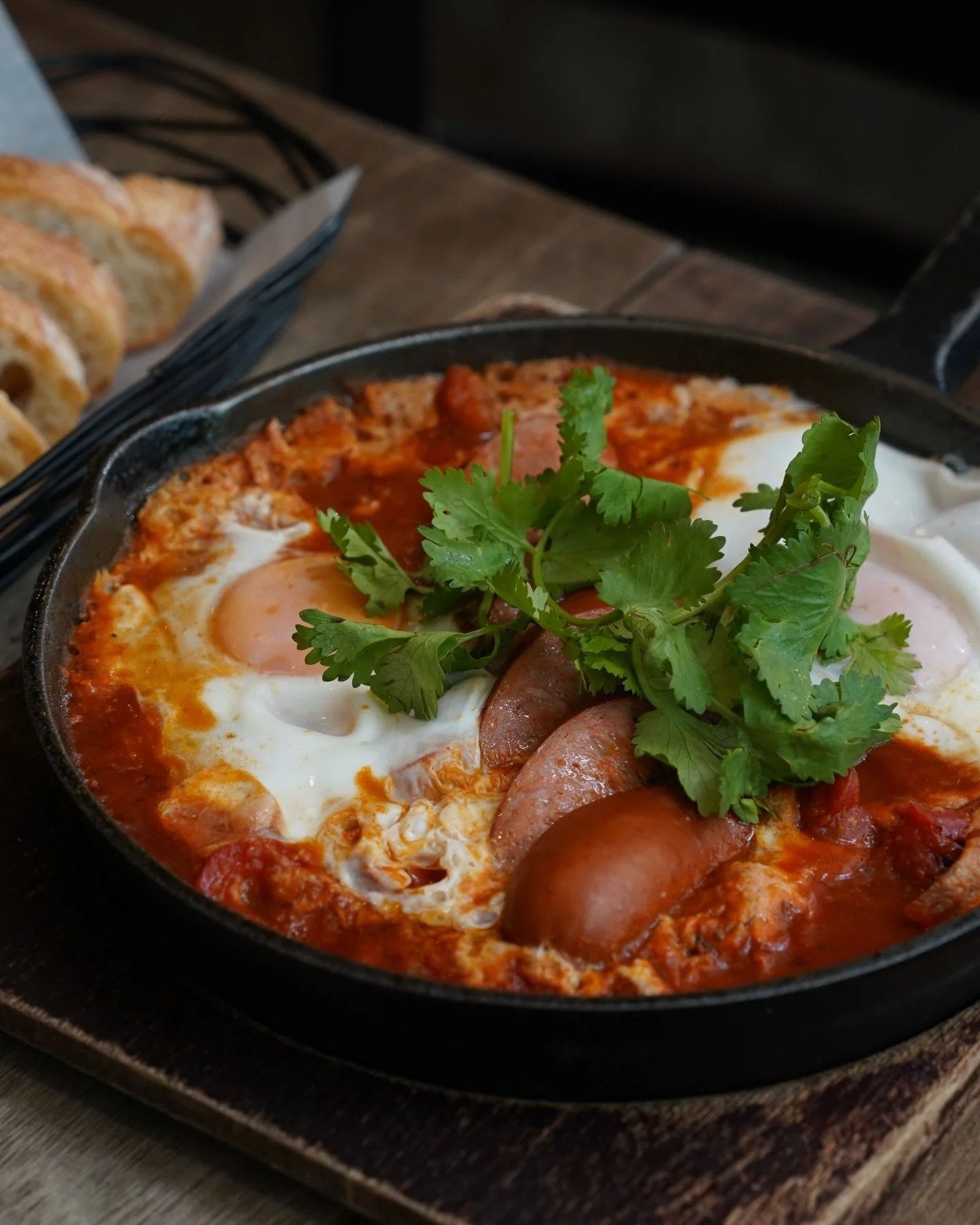 Two sunny side up eggs in a red pepper harissa ragout with chilli cheese kransky and toasted baguette, warm, saucy, and best mopped up slowly.

Weekend brunch plan!
