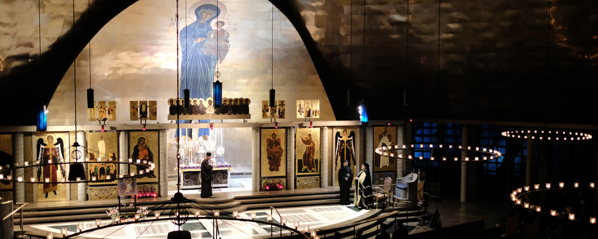 Interior of a Greek Orthodox church featuring Byzantine iconography on the ceiling