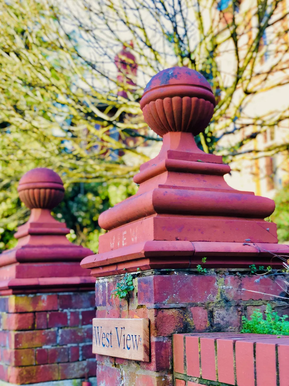 Pink turned wood on brick posts.jpeg
