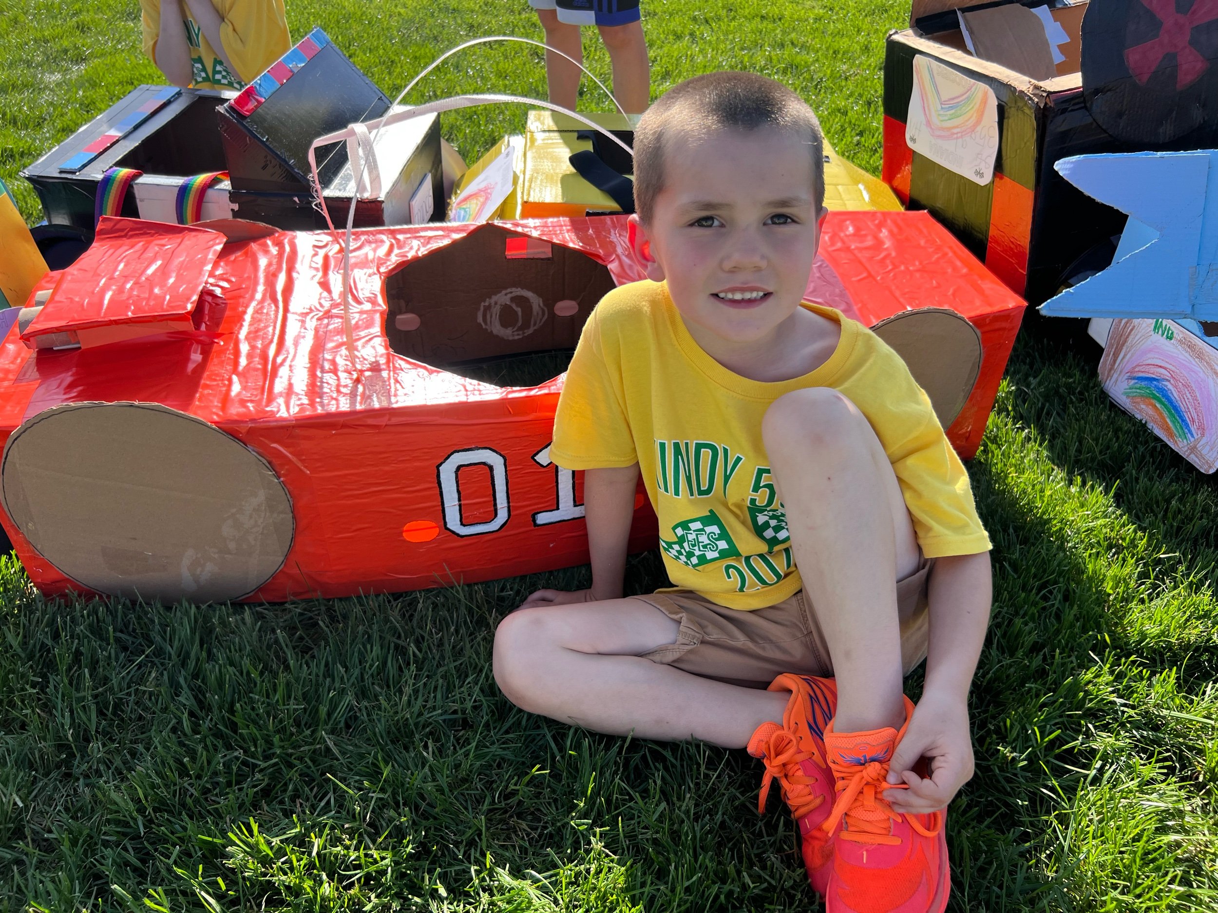 Hudson Hobbs sits proudly next to his Dukes of Hazard car