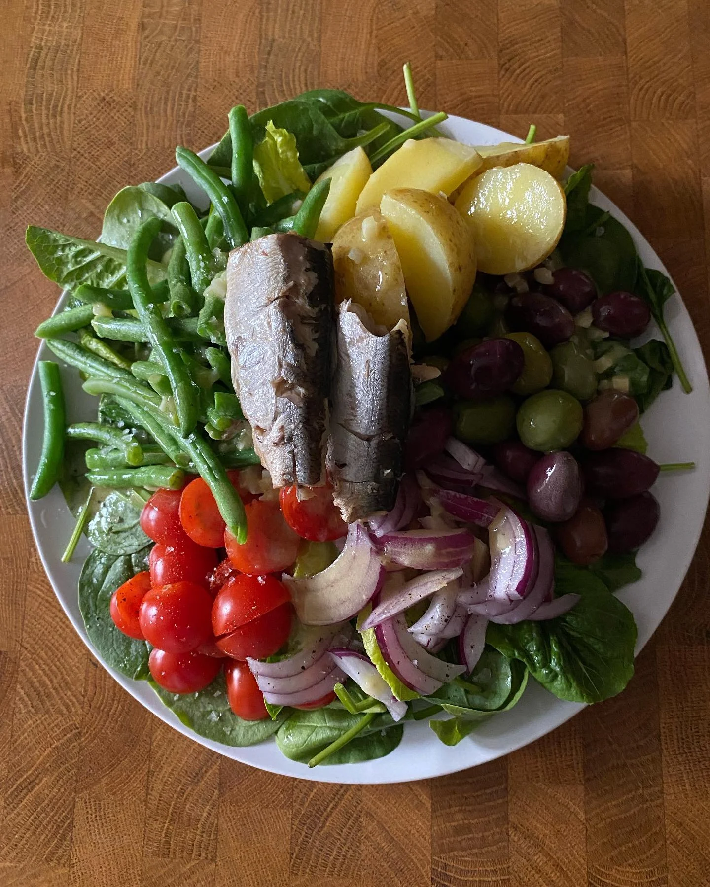 Salade Ni&ccedil;oise but not really
Sardines 
Boiled potatoes
Steamed green beans 
Cherry tomatoes 
Olives 
Red onion 
On a bed of spinach 
Topped with a garlic &amp; mustard vinagrette