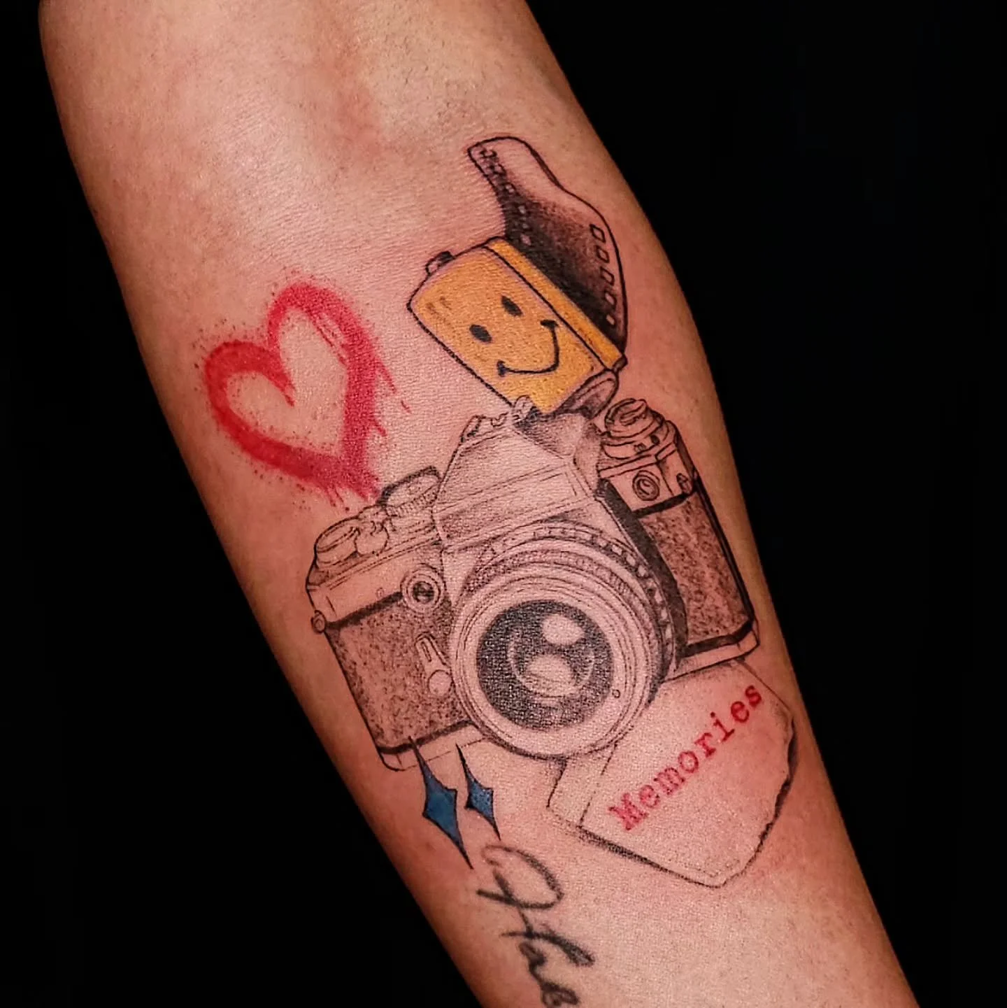 Some tattoos are about aesthetics. Others are about keeping a memory close. 📷❤️

This custom camera piece is filled with little details that make it feel personal &mdash; from the smiley camera strap to the heart and handwritten elements surrounding