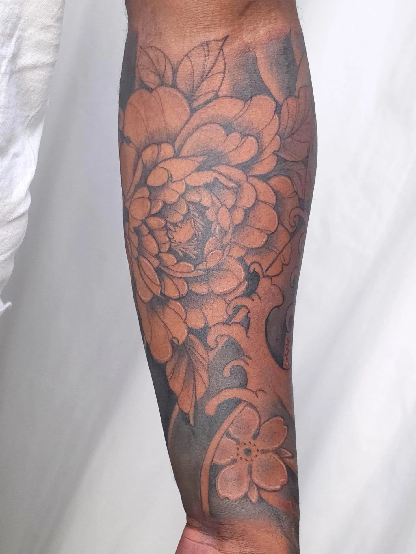 Black &amp; grey Japanese Traditional Style  florals on deeper skin tones 🤎 This piece is all about contrast, intentional negative space and bold enough shading to complement melanin-rich skin beautifully. The darker background helps the florals sta