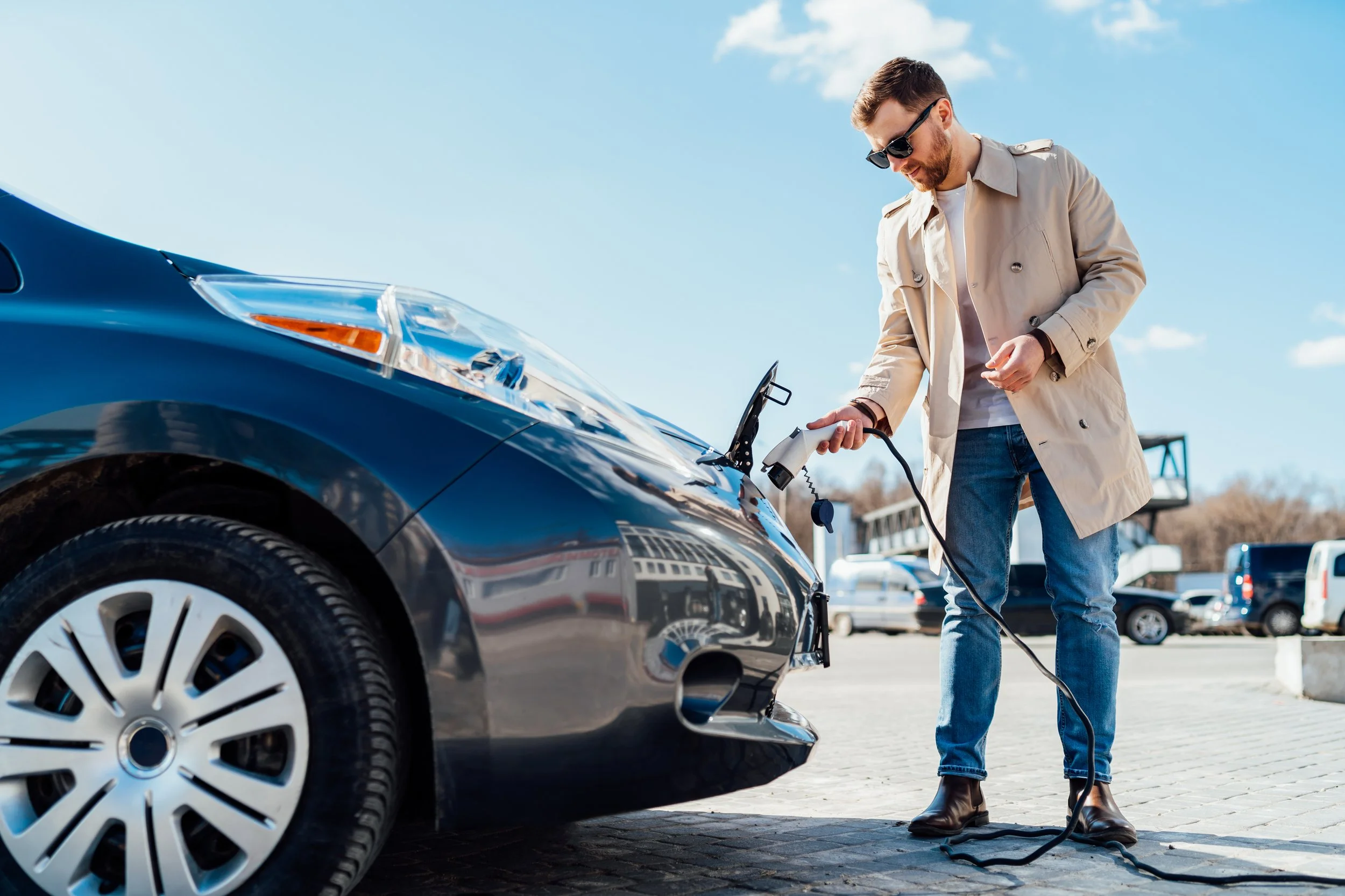 stylish-man-in-sunglasses-inserts-the-charging-cab-2022-02-02-22-26-16-utc.jpg