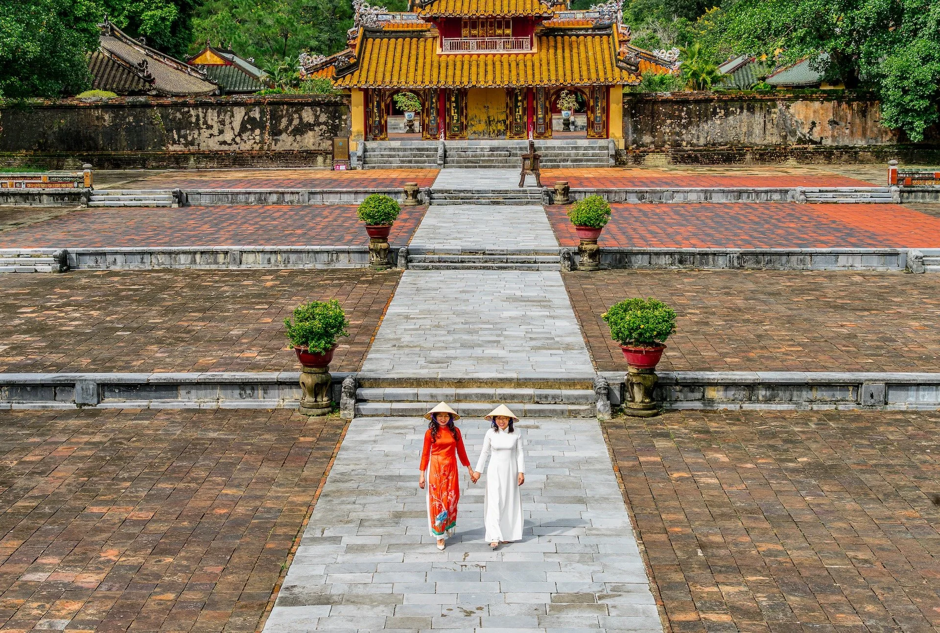   An old Vietnamese palace reflects imperial power, craft, and mixed influences within walled gardens, ponds, and courtyards. Timber halls with sweeping tiled roofs, carved beams, lacquered doors, and painted rafters blend Vietnamese symmetry and lan