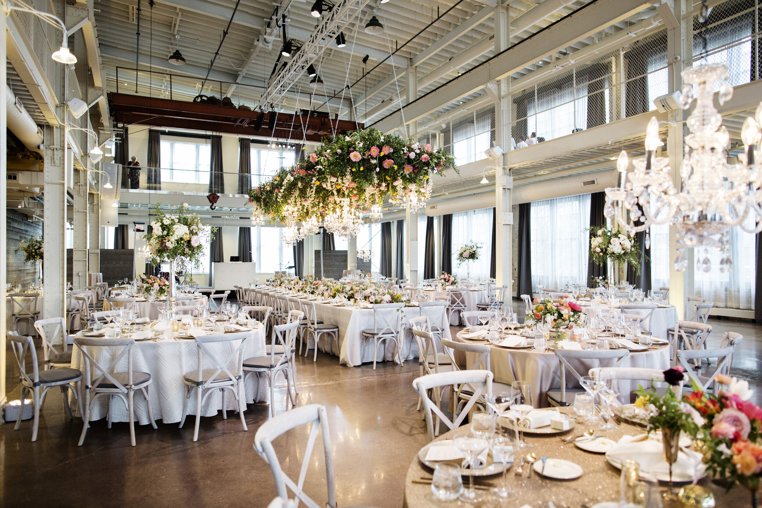 Elegant banquet hall decorated with flowers and chandeliers for a wedding or event.
