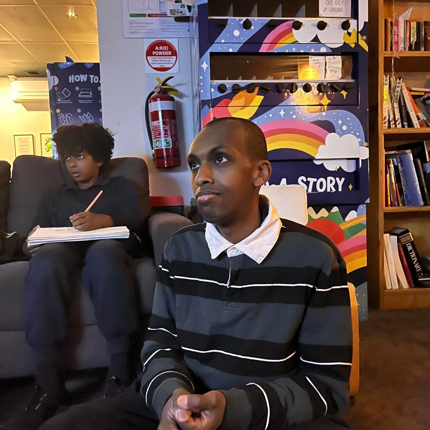 Meet Mo (he/him):

Mohamed (Mo) Sudi is a Somali poet, storyteller and calligrapher. His journey has taken him from Mogadishu, through a refugee camp in Kenya, to Australia. Mo mixes spoken word, Somali storytelling and Arabic calligraphy to share st