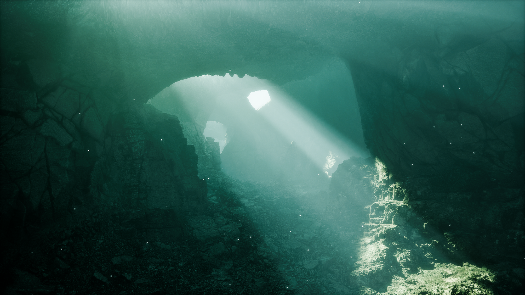 Underwater cave with sunlight streaming through openings, illuminating rocky walls and floor.