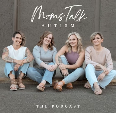 Four women sitting on the ground, smiling, with a sign behind them that says 'Mom's Talk Autism' and 'The Podcast'.
