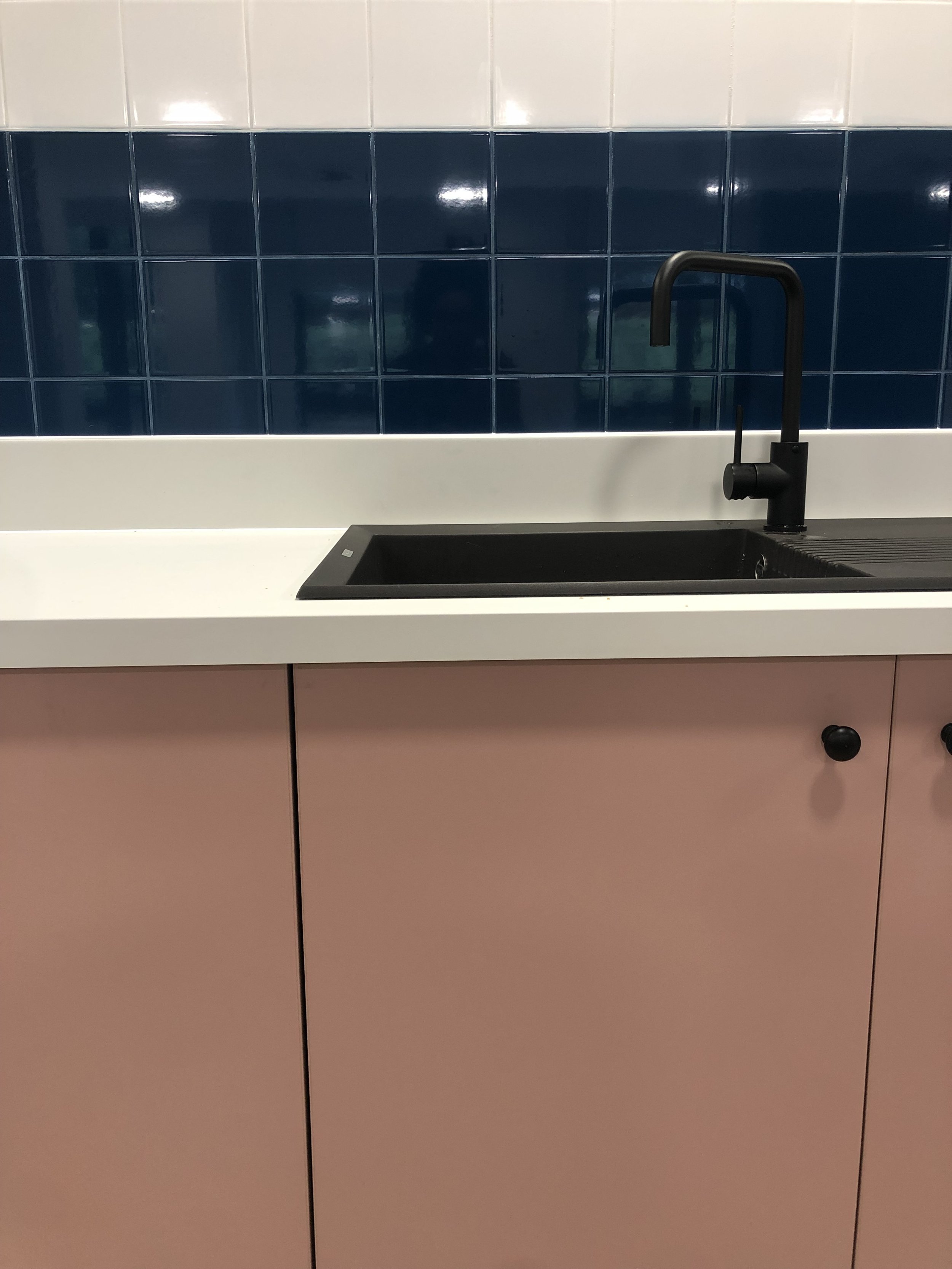 Pink kitchen with blue and white tiled wall