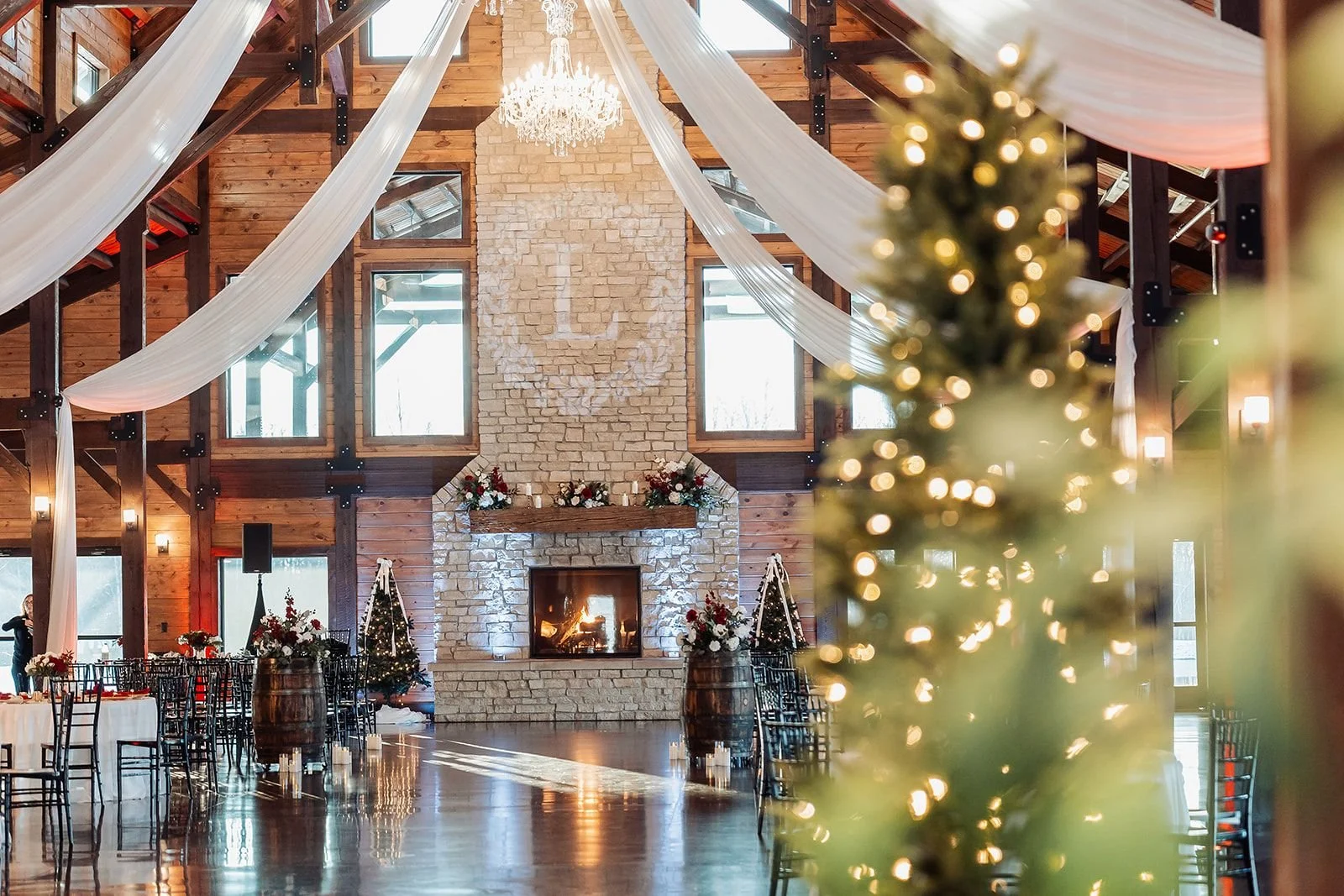 Romantic Christmas styled wedding with holiday decor, roaring fire, soft lighting and luxury tables & chairs.