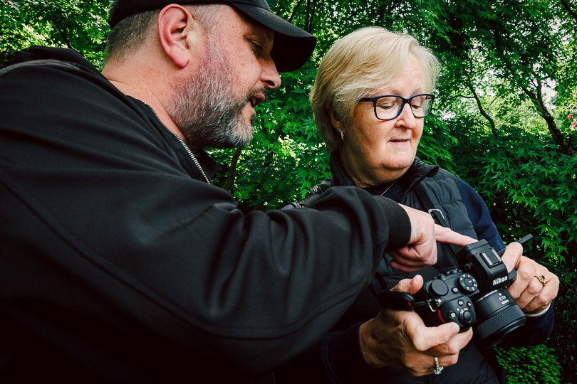Dave shows a photography workshop client in Manchester some of the settings on her Nikon camera
