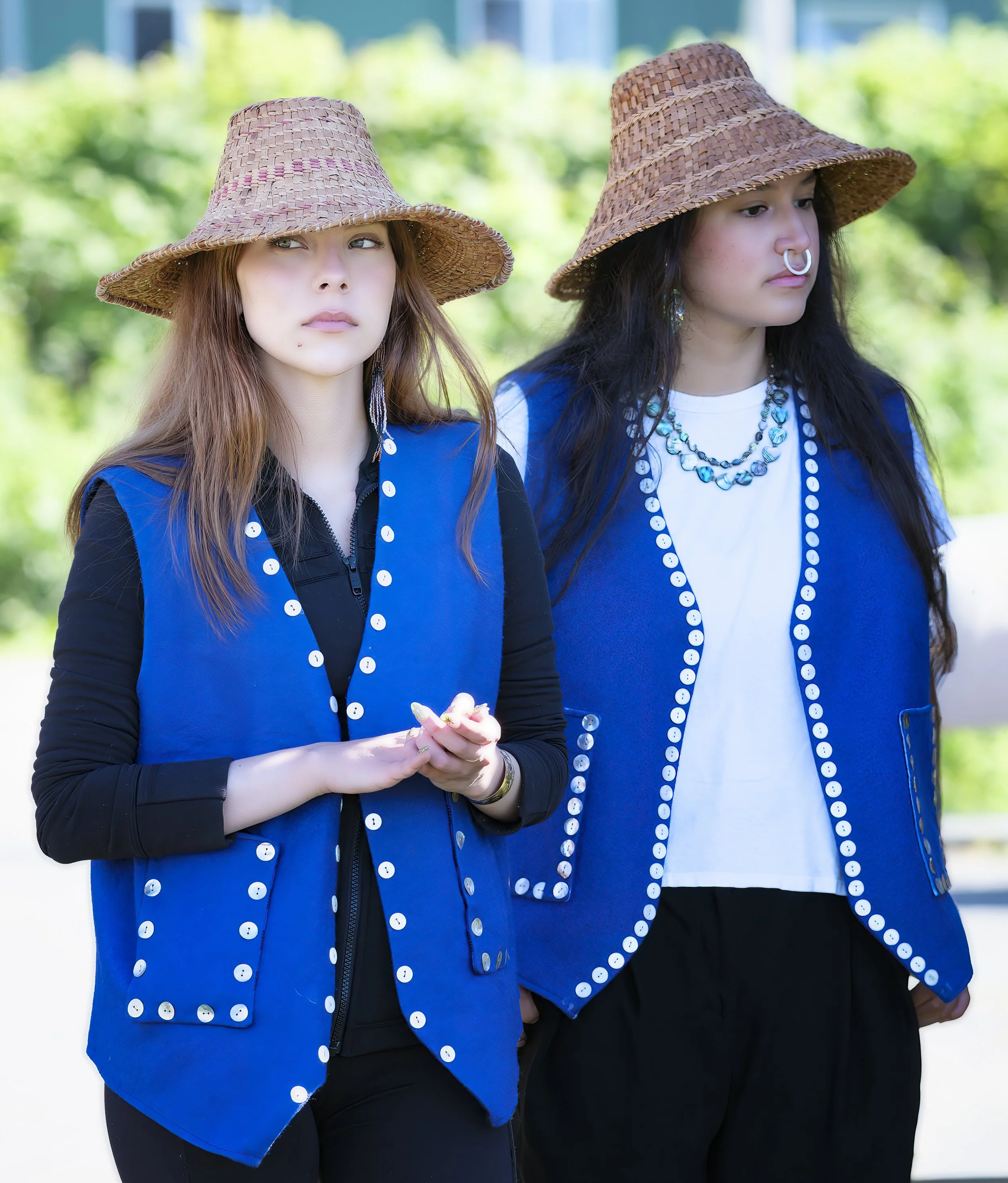 Two girls wearing Tlingit style of clothing, talking about Tlingit traditions, storytelling, and clan relationships. Kake is a Tlingit cultural center.