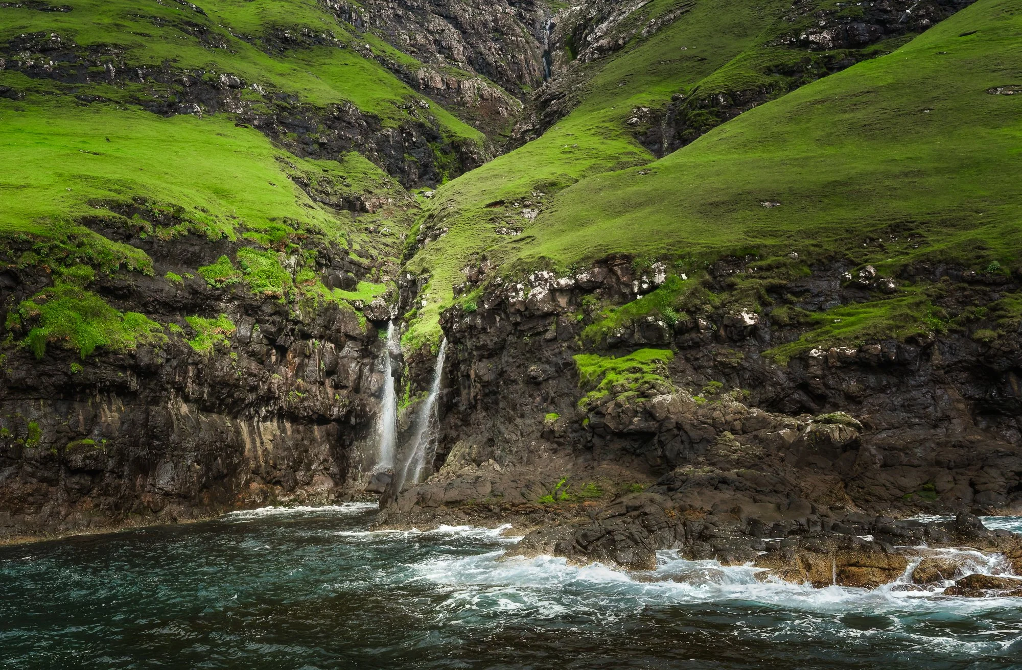 Vestmanna Sea Cliffs, Faroe Islands. Waterfalls are abundant on the hillside. There is so much rain. 