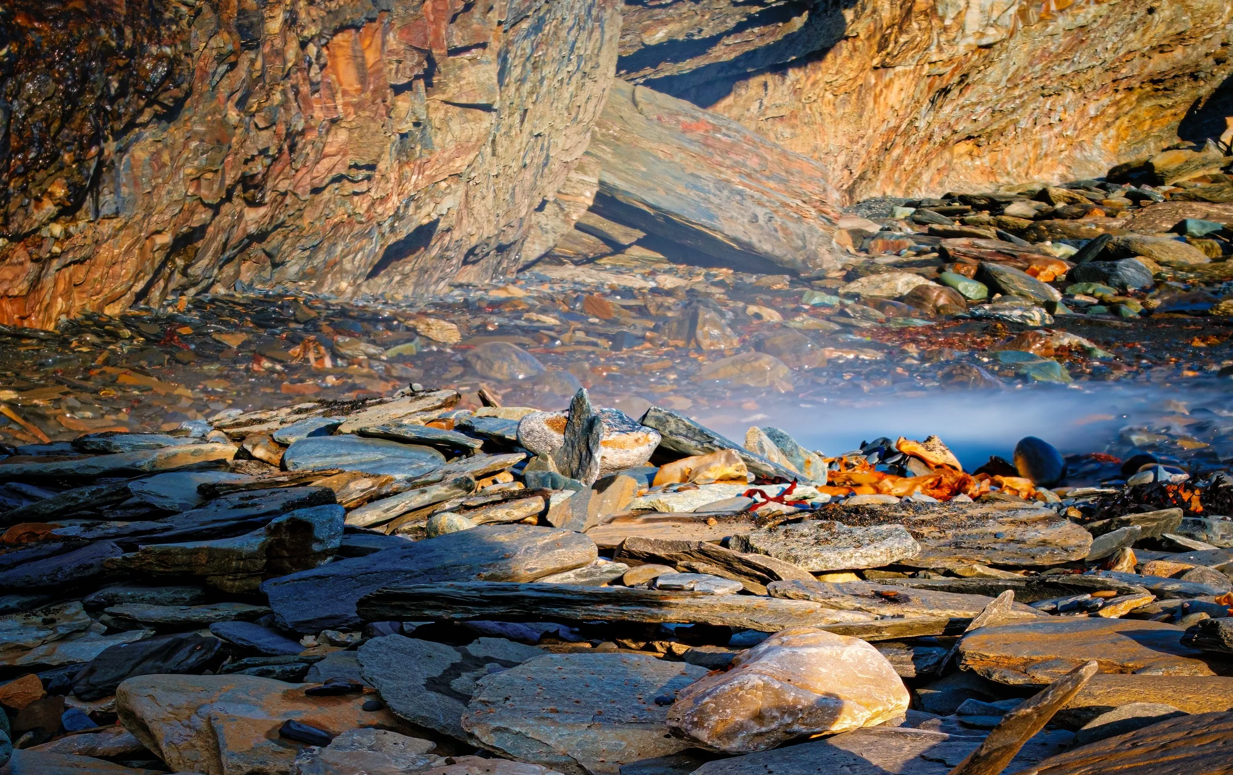 Erosion of the ancient mountains by a process called exfoliation.  See how the rocks seem to peel off?  