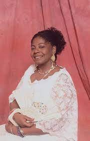 Amma D. McKen has been a lifelong member of a vibrant community who describe themselves as Yoruba traditionalists or Lukumi, practicing a way of life and religion of West Africa. Born and raised in Brooklyn, New York, McKen has sung traditional sacre