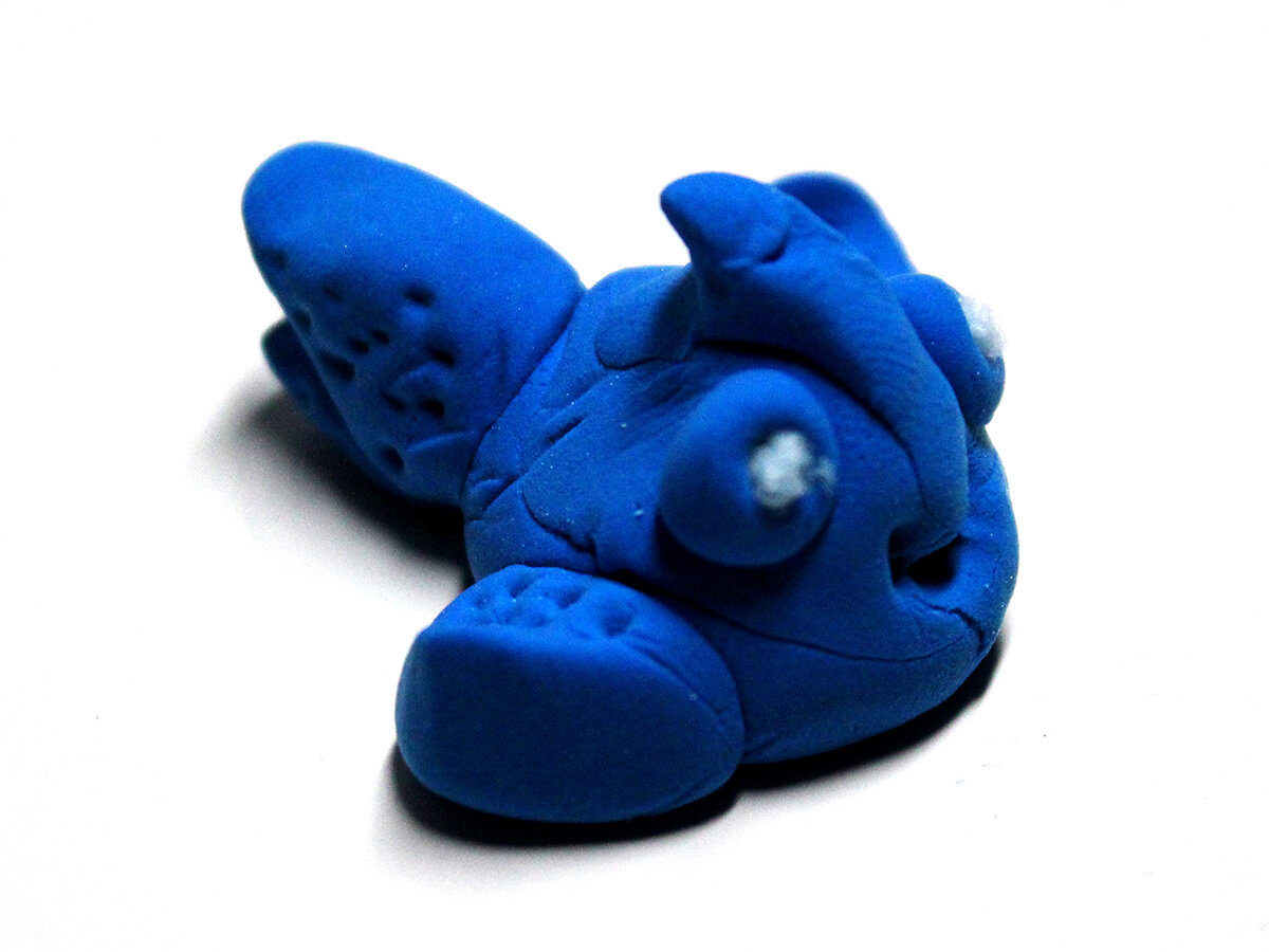 Small blue clay fish with carved fin designs (side)