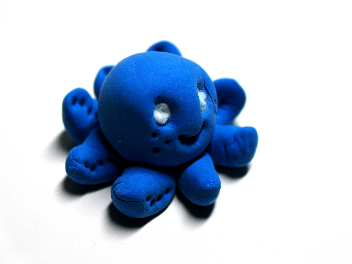 Small blue clay octopus with white eyes (3/4 view) 