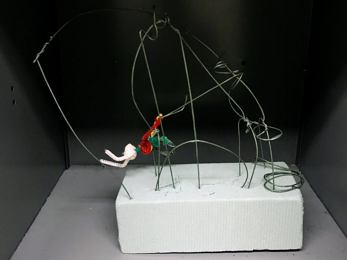 Grid pattern sculpture with pipe cleaner figure
