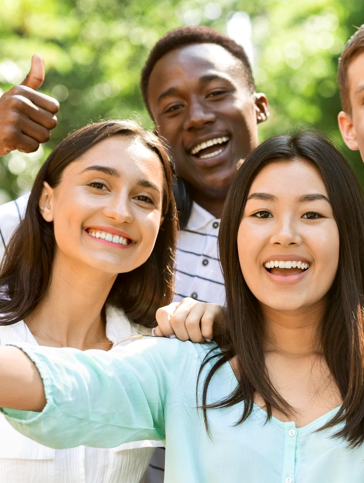 Teens looking forward one with a thumbs up