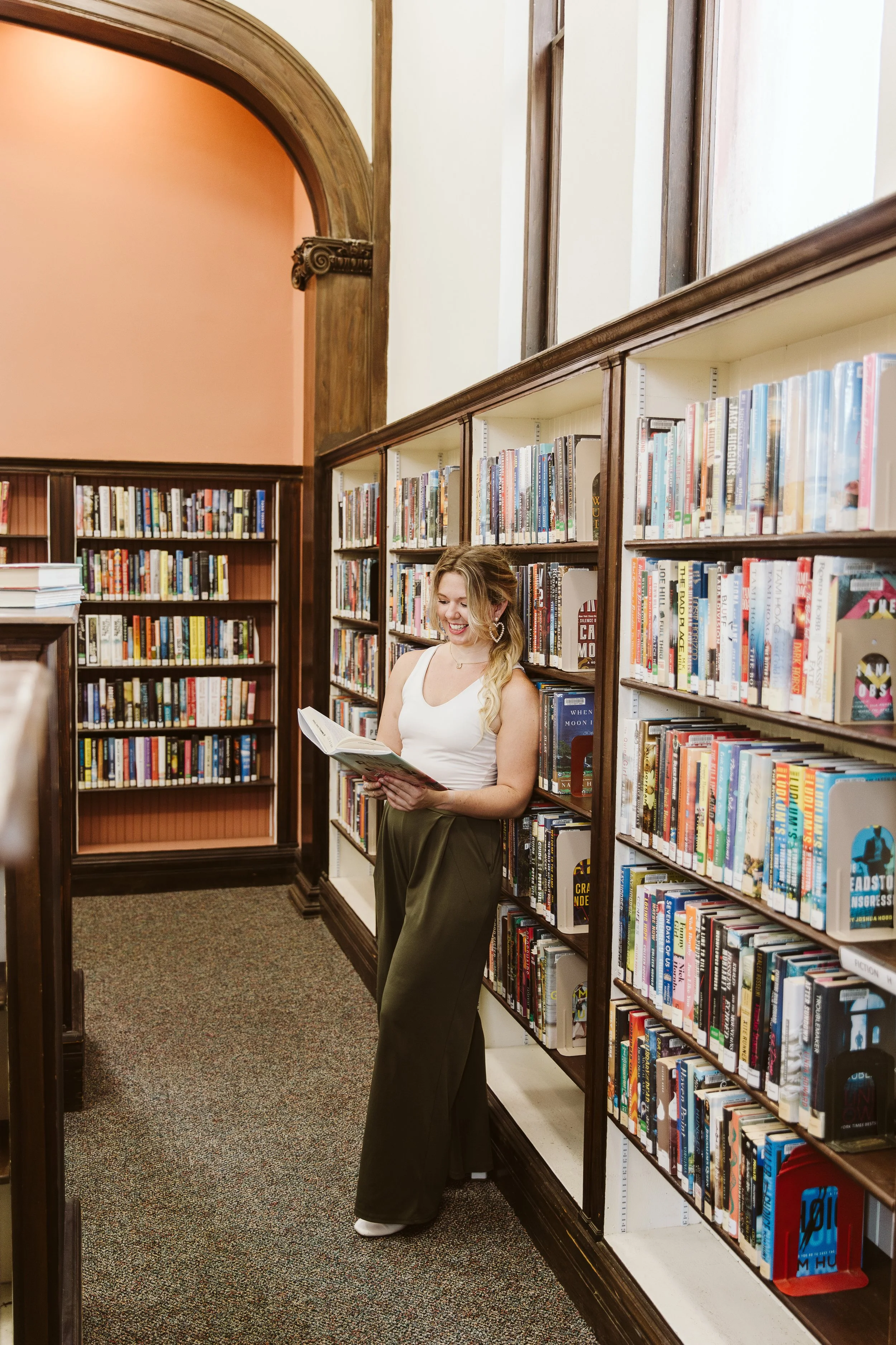 Tiffani, sEO website copywriter, reading a book in a library about SEO Packages for Small Businesses