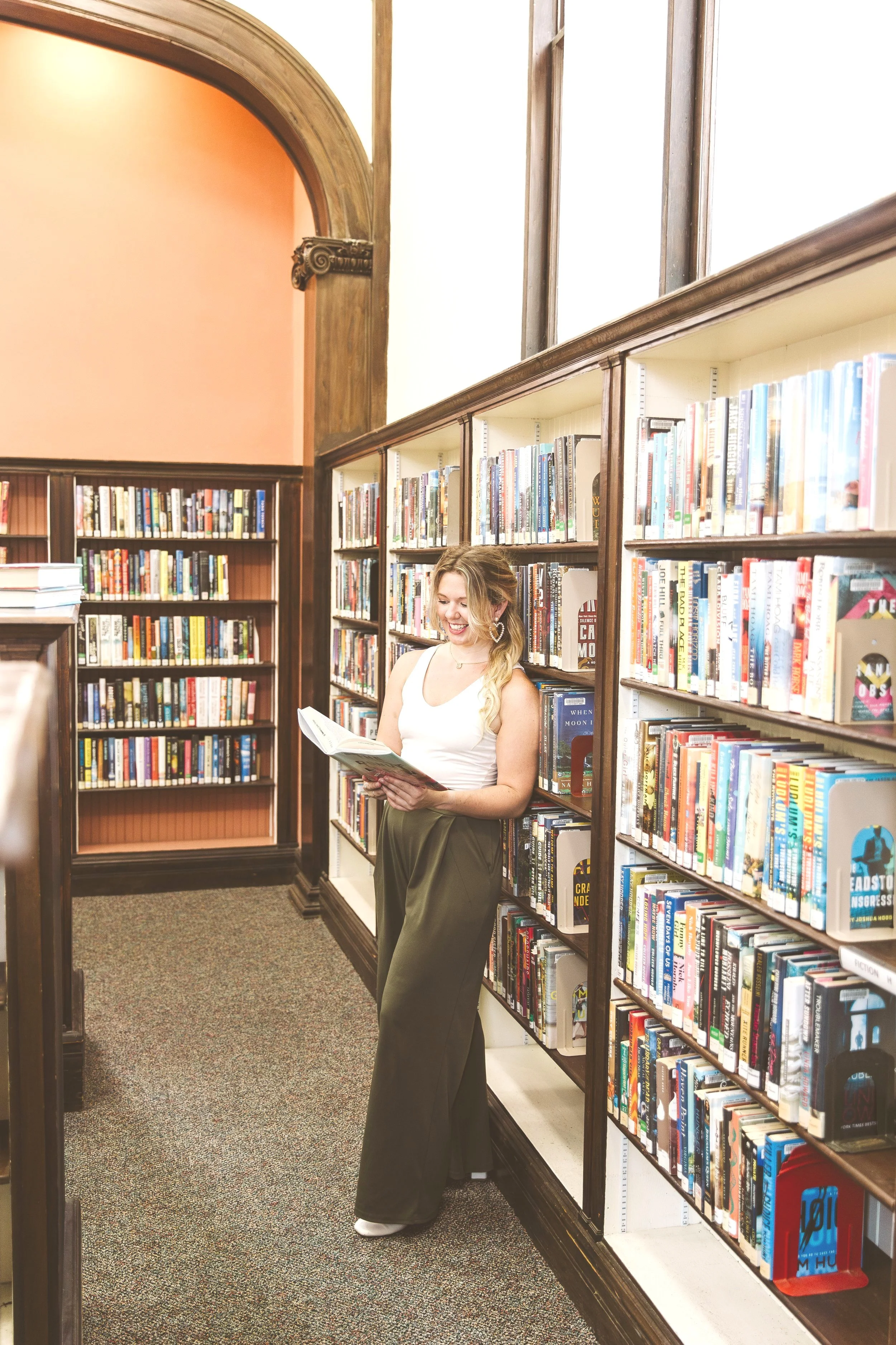 Tiffani, an SEO website copywriter, reading in a quiet library—part of her Website Copywriting Services & Packages brand imagery.