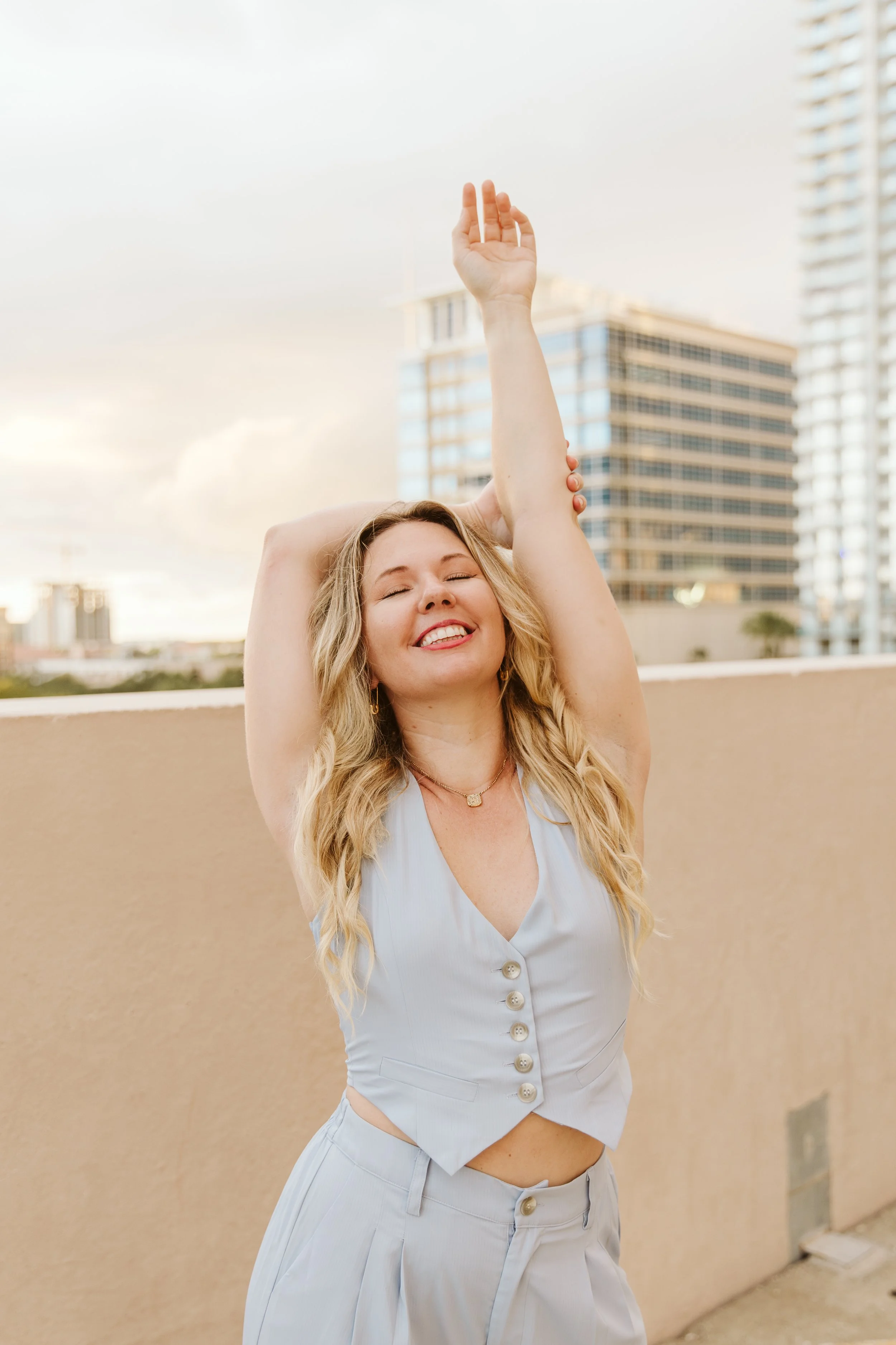 blonde woman in blue outfit against city backdrop