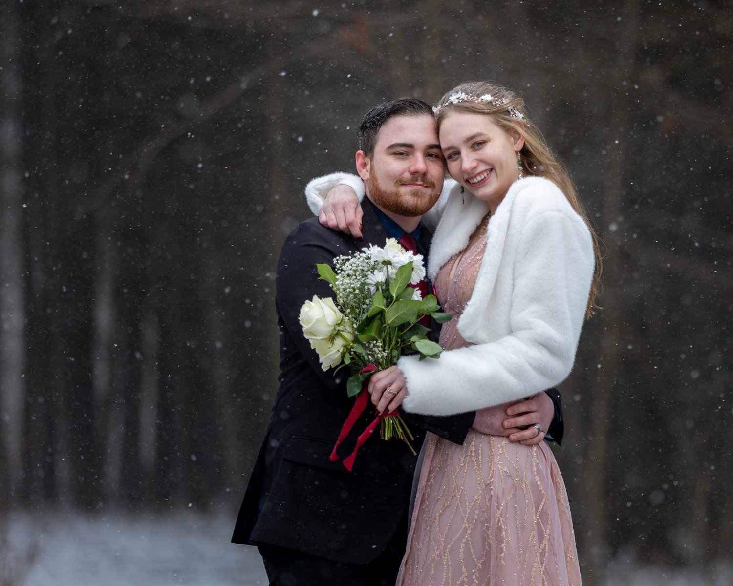 Winter wedding couple with snowflakes falling