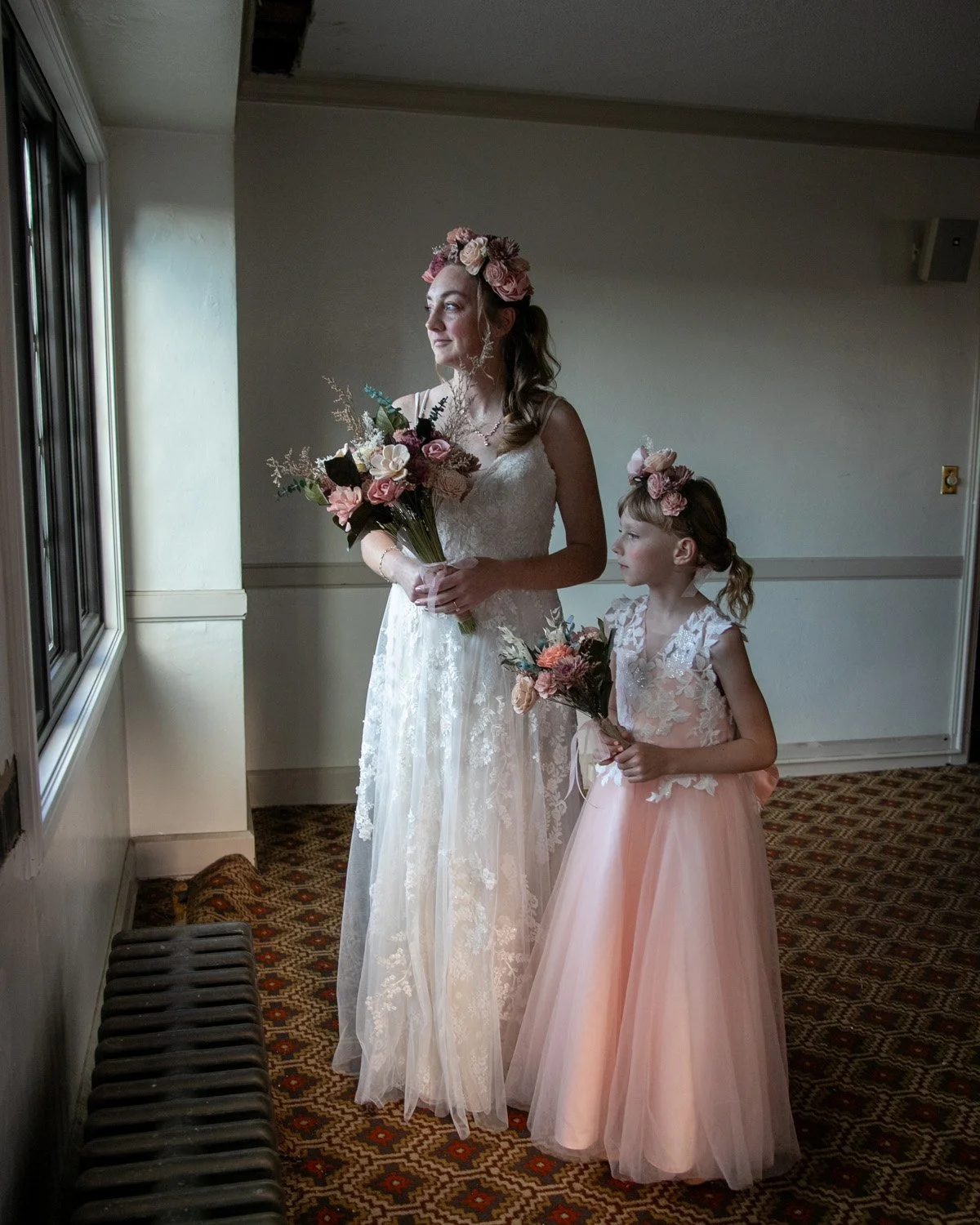 Bride and her flower girl looking out window at Hofbrauhaus