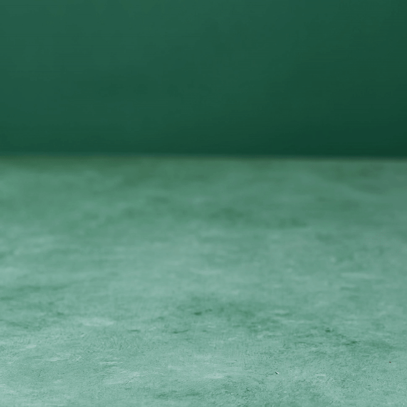 Silhouette of a person with arms raised, jumping on a green background with confetti.