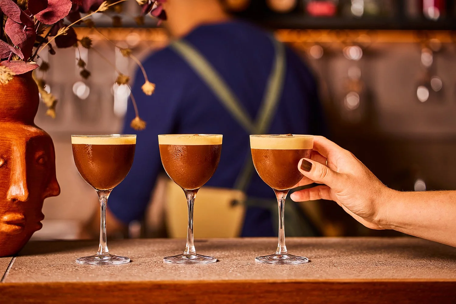FoodPhotographerLondon_CharlotteNott-Macaire_Wahaca_EspressoMartiniOnBarWithHandHolding.jpg