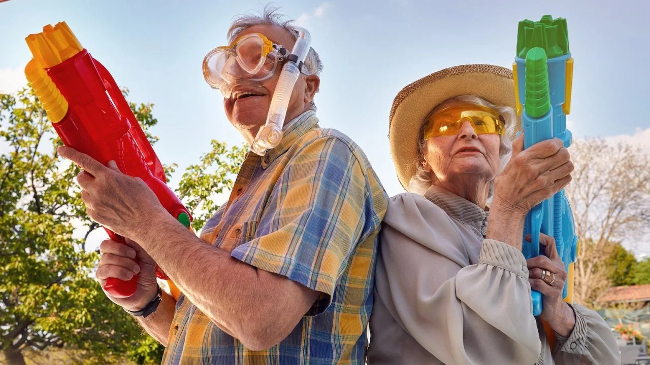 Older couple having fun with water guns