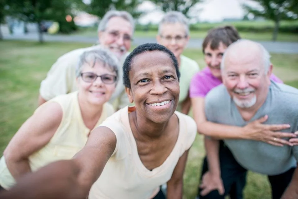 Diverse group of people of different ages and races smiling at the camera