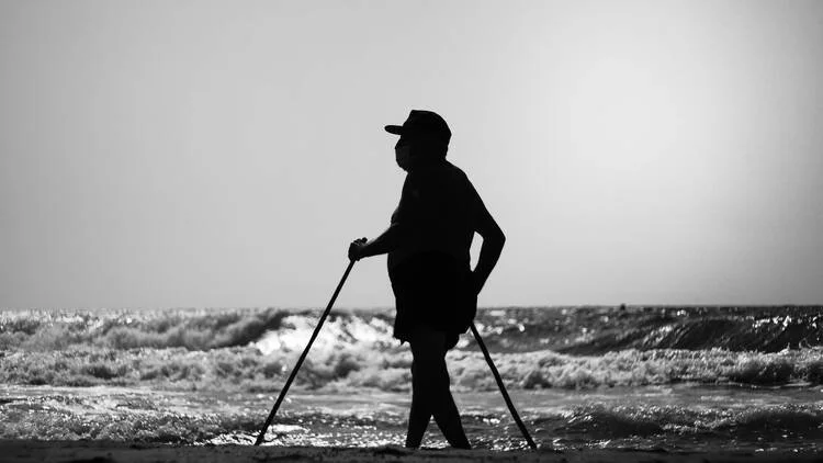 Silhouette of a midlife aged man walking on the beach
